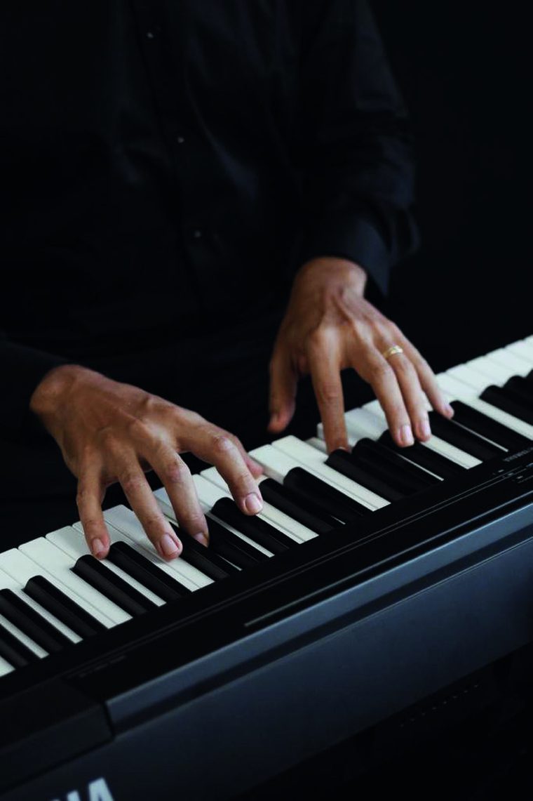 Mãos ao piano em close, detalhe da técnica